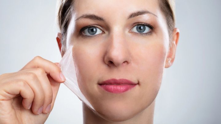 Femme avec une peau fine tenant un masque transparent, illustrant les effets du vieillissement sur l'épiderme et les solutions esthétiques pour améliorer la texture de la peau.